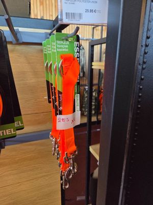 an orange leash hanging from a metal rack in a store