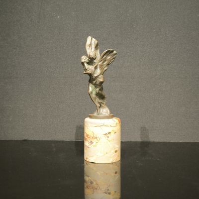 statue d'une femme tenant un oiseau, posée sur un socle en marbre