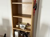 a wooden bookcase with a lot of books on top of it