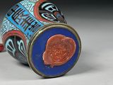 an image of a blue and red vase with a red handle