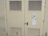 deux portes situées sur le côté d'un immeuble sur lequel est accrochée une enseigne