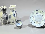 three vases and a plate on display on a table