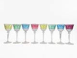 six multicolored wine glasses are lined up in a row