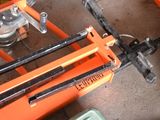 an orange scissor sitting on top of a table next to a green container