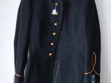navy blue jacket with gold buttons on a hanger on a white wall