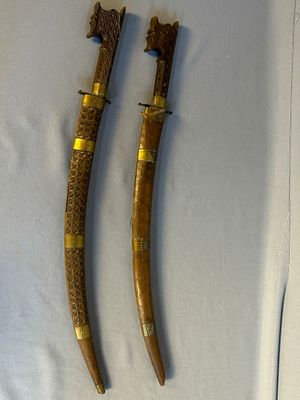 Il s'agit de deux morceaux de bois qui ont été sculptés pour ressembler à des sabres.