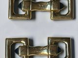 pair of brass plated buckles on a white background