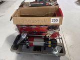 two boxes of tools sitting on a cart on the floor