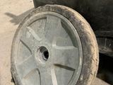 a wheel that is sitting on the ground next to a car