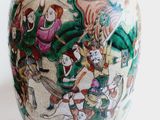 a vase with a painting on it sitting on a table