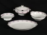 four pieces of white and pink china on a black background