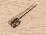 a piece of metal on a wooden surface with a pair of scissors