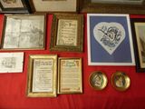 a table with a red table cloth covered with pictures and framed pictures