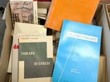 several books are stacked in a box on a table