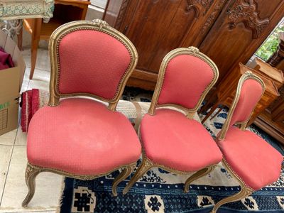 three red chairs sitting on top of a blue rug in a living room