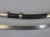 two swords with black and silver handles on a white surface