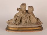une statue représentant un garçon et une fille posée sur une table