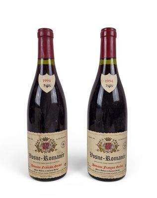 deux bouteilles de vin rouge posées l'une à côté de l'autre sur une surface blanche