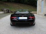 a black sports car parked in a driveway near a building