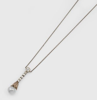 un gros plan d'un collier composé d'une perle montée sur une chaîne