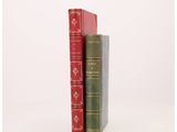 two red and green books sitting next to each other on a white surface