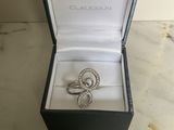 a close up of a ring in a box on a marble surface