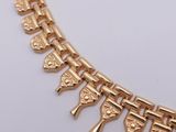an image of a gold necklace on a white surface