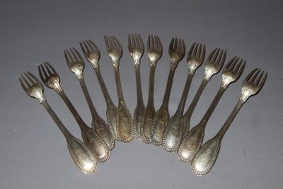 six forks are arranged in a circle on a gray surface