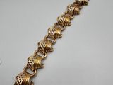 a gold plated bracelet with an intricate design