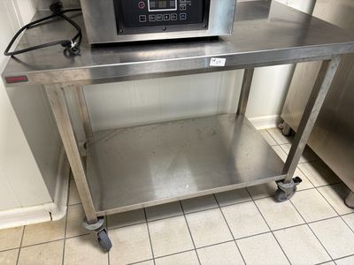 un micro-ondes posé sur une table en inox dans une cuisine