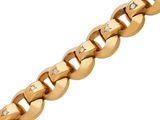 gros plan d'un bracelet en or avec des diamants sur fond blanc