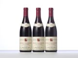 three bottles of red wine sitting on top of a table