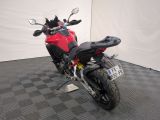 a red motorcycle parked in a room with a checkered floor