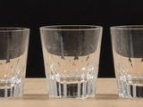 four shot glasses lined up on a wooden table with a black background