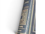 an old blue book sitting on top of a table next to a white wall