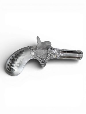 objet argenté en forme de pistolet posé sur une surface blanche, sur fond blanc