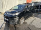 une camionnette noire garée devant un immeuble, sur un parking