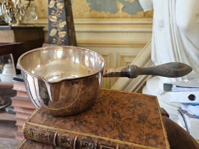 un bol en argent posé sur une pile de livres