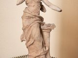 une statue de femme assise sur une table