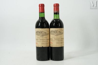 deux bouteilles de vin rouge posées l'une à côté de l'autre sur une surface blanche