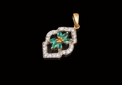 un pendentif en forme de fleur, composé d'une émeraude et de diamants, sur fond noir