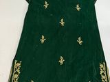 a green and gold embroidered dress with gold trim