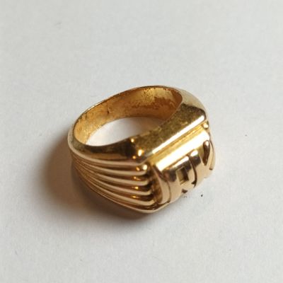 une bague en or posée sur une surface blanche