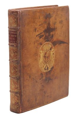 an old book with a gold medallion on the front cover