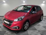 une voiture rouge est garée dans une pièce au sol en damier