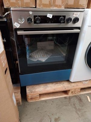 une pile de cartons derrière un poêle et une machine à laver