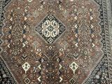 an image of a brown and black oriental rug on a wooden floor