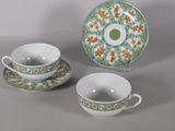 two cups and a saucer sitting on a table