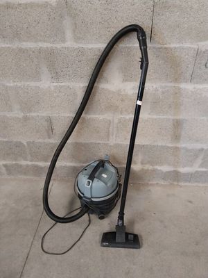 a vacuum that is sitting on the ground next to a brick wall