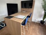 a desk with two chairs and a television in the corner